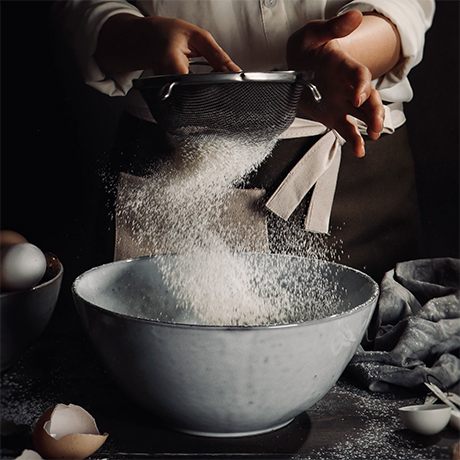 Sifting flour to make pancakes for Pancake Day