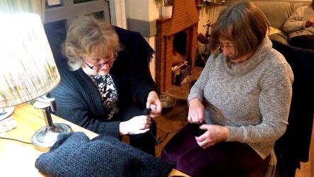 Carolyn and Fiona unravelling Anna's mammoth shawl - Knit & Natter Club - February 2023 - Green Man in Toppesfield